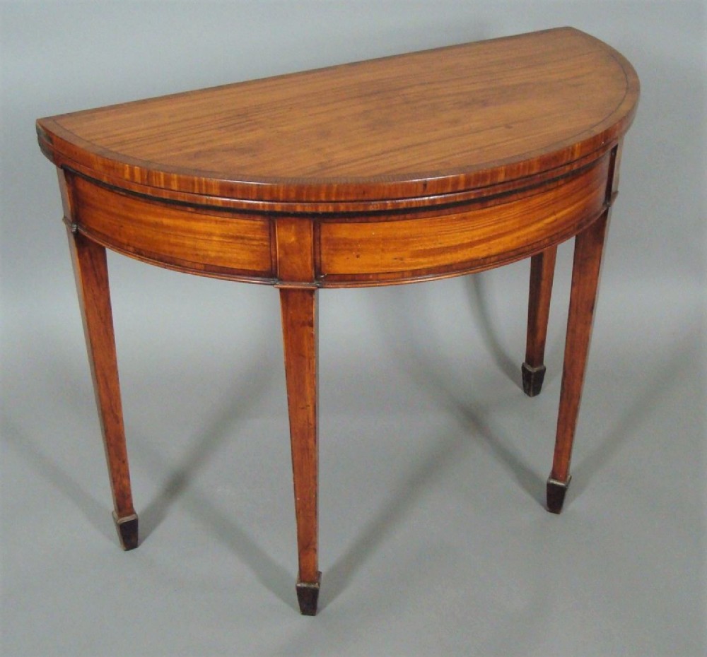 George III Satinwood demilune card table; in the Sheraton manner with an excellent colour