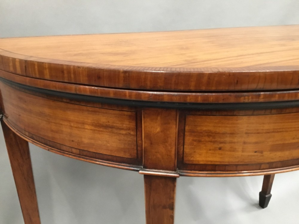George III Satinwood demilune card table; in the Sheraton manner with an excellent colour View X