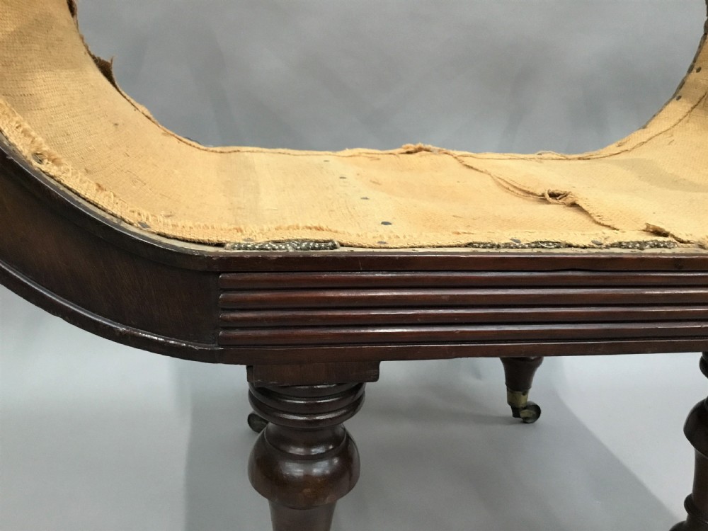 A Regency mahogany window seat with reeded scroll arms, turned legs on brass castors, and a calico-covered seat. View VII