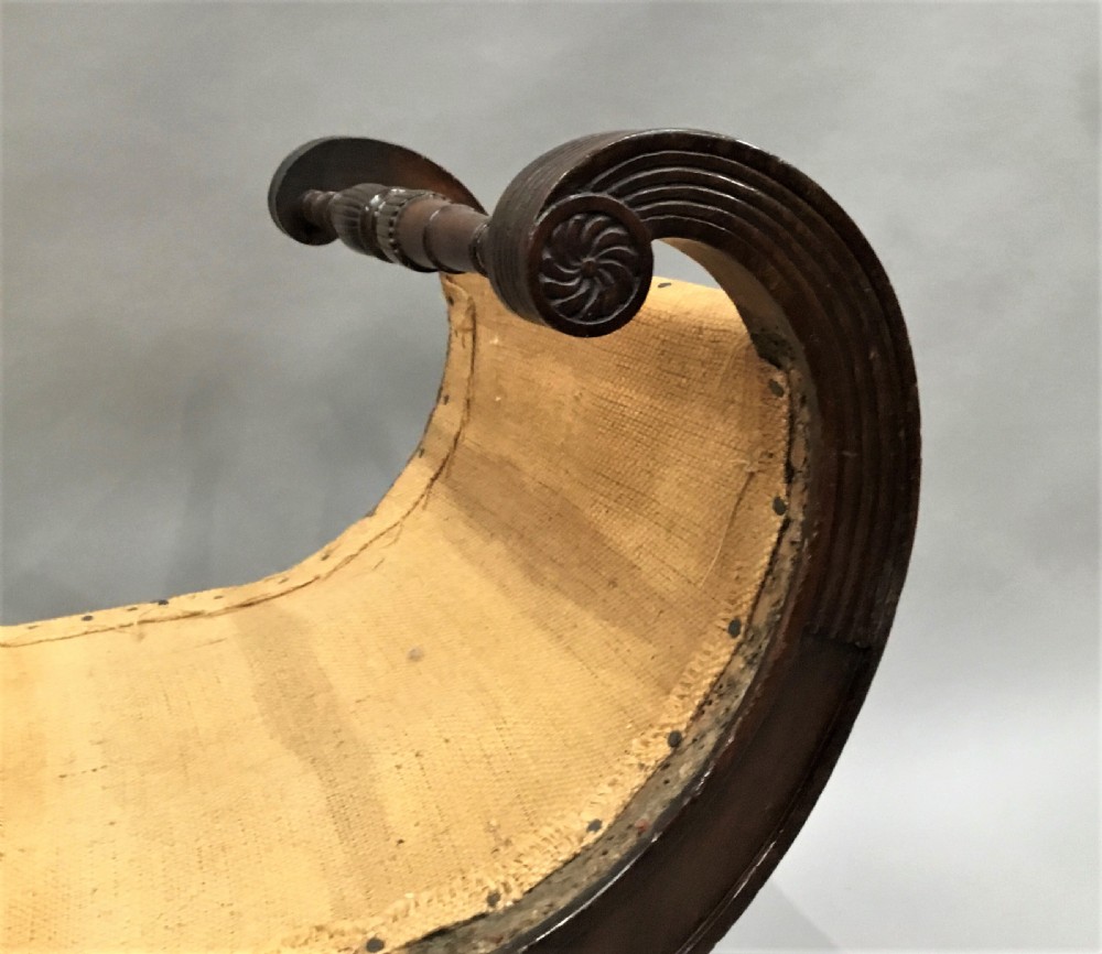 A Regency mahogany window seat with reeded scroll arms, turned legs on brass castors, and a calico-covered seat. View XI