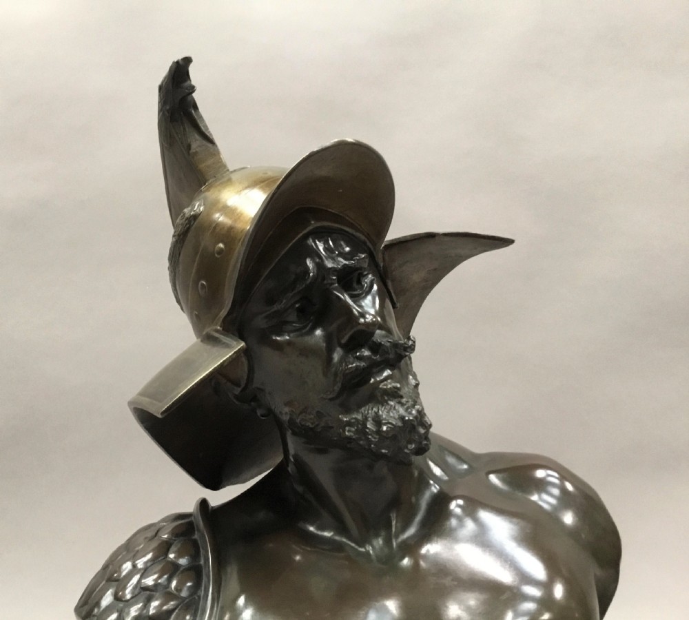 A 19th-century dark bronze bust depicting a helmeted Roman gladiator with a beard, mounted on a square variegated pink marble base. View XI