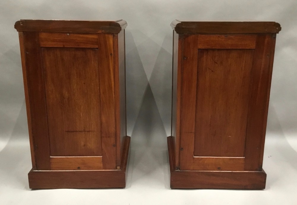 A pair of tall, narrow mahogany Wellington chests featuring four drawers each, turned brass knobs, and carved roundel pilasters on plinth bases. View XI