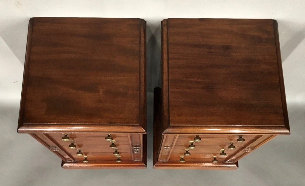 A pair of tall, narrow mahogany Wellington chests featuring four drawers each, turned brass knobs, and carved roundel pilasters on plinth bases. View XIV
