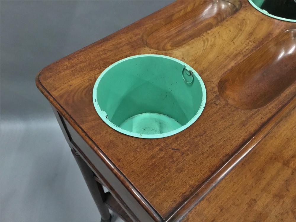 A French Louis XVI style mahogany rafraichissoir wine table with two inset metal bottle coolers, lower tiered shelves, and turned fluted legs on castors. View XV