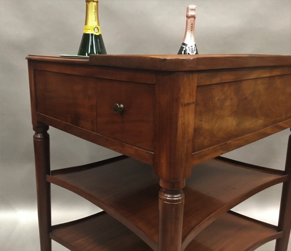 A French Louis XVI style mahogany rafraichissoir wine table with two inset metal bottle coolers, lower tiered shelves, and turned fluted legs on castors. View XVI