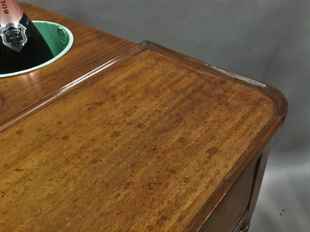 A French Louis XVI style mahogany rafraichissoir wine table with two inset metal bottle coolers, lower tiered shelves, and turned fluted legs on castors. View XVIII