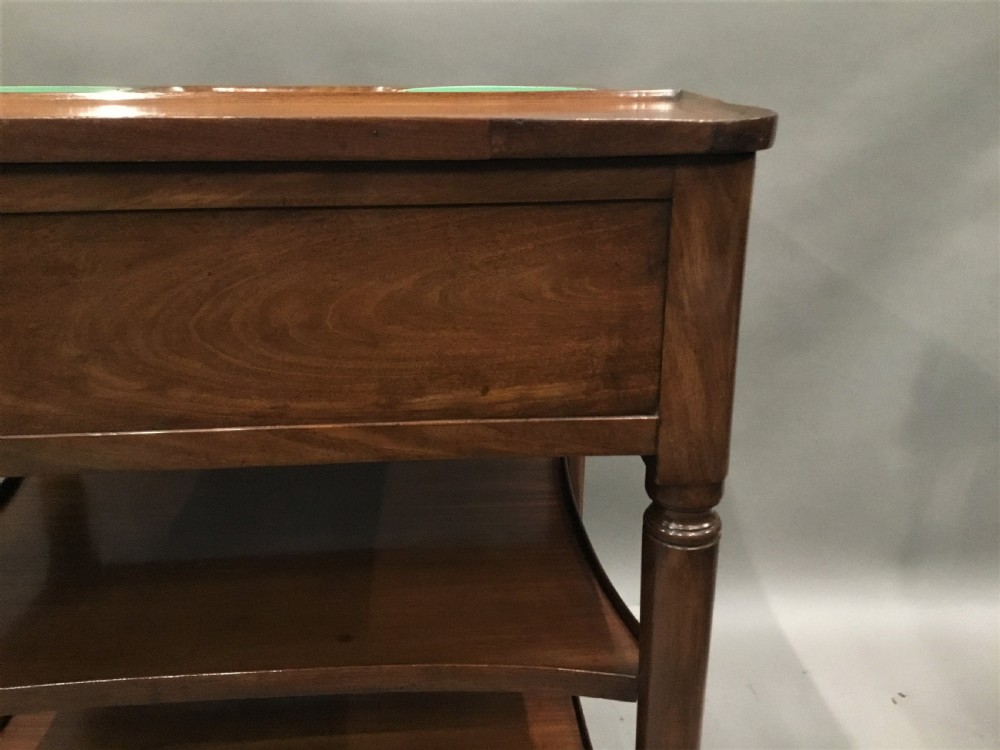 A French Louis XVI style mahogany rafraichissoir wine table with two inset metal bottle coolers, lower tiered shelves, and turned fluted legs on castors. View XIX