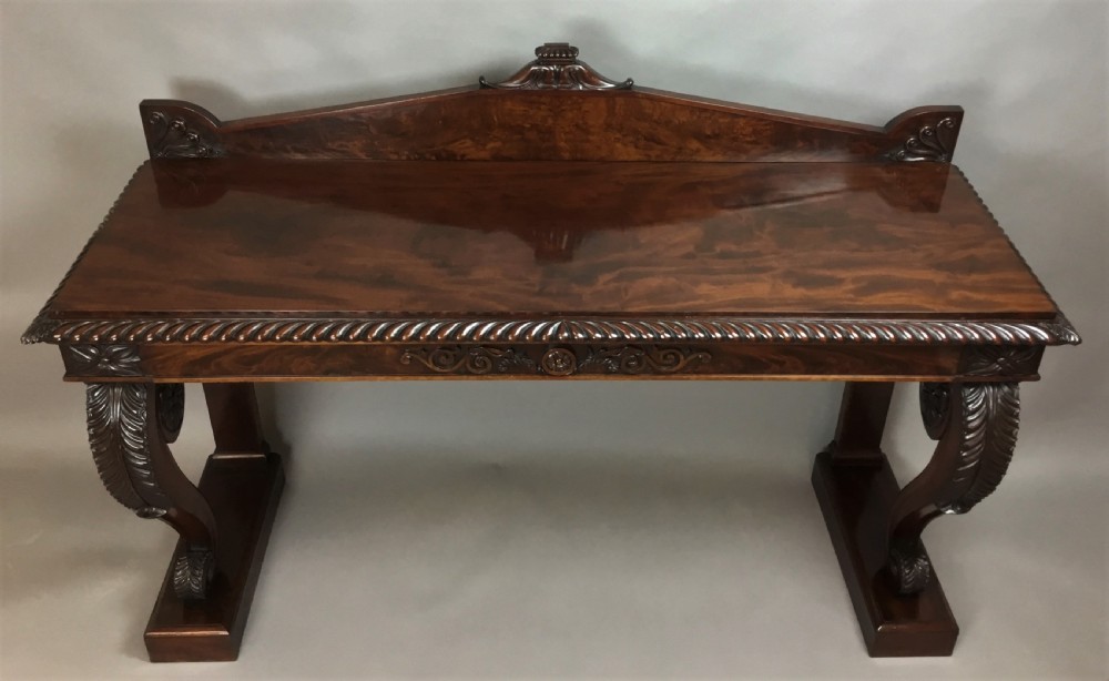 A Regency period dark mahogany serving table featuring carved scroll legs with acanthus leaves, a gadrooned top edge, and a raised carved backrail. View VI