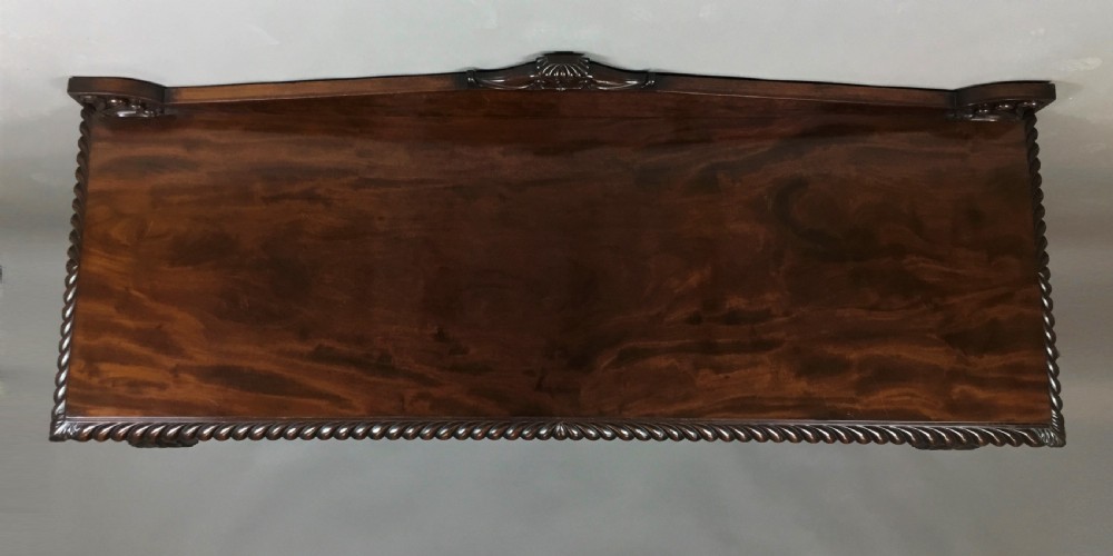 A Regency period dark mahogany serving table featuring carved scroll legs with acanthus leaves, a gadrooned top edge, and a raised carved backrail. View XII