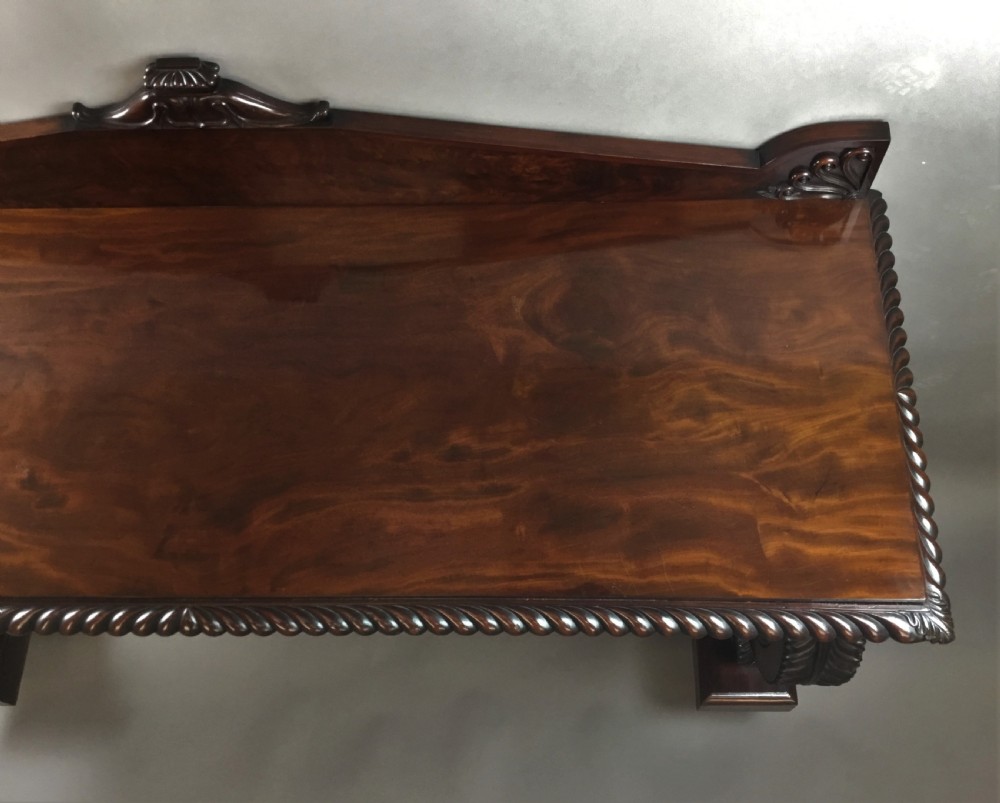 A Regency period dark mahogany serving table featuring carved scroll legs with acanthus leaves, a gadrooned top edge, and a raised carved backrail. View XVII
