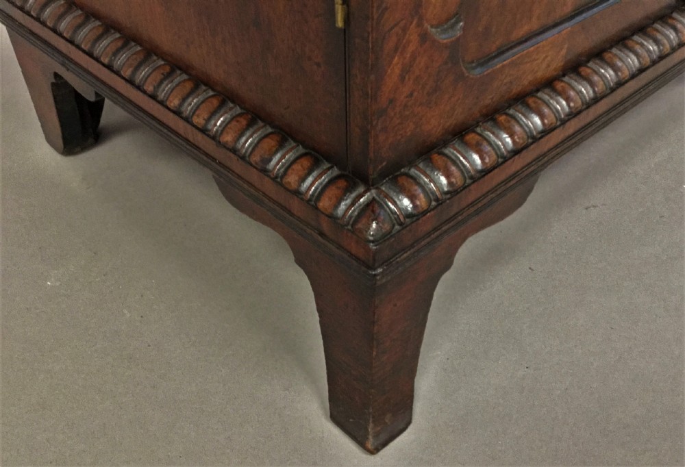 A Regency period mahogany secretaire cabinet featuring flame mahogany veneered doors with re-entrant corners, gadrooned borders, and bracket feet. View XIV