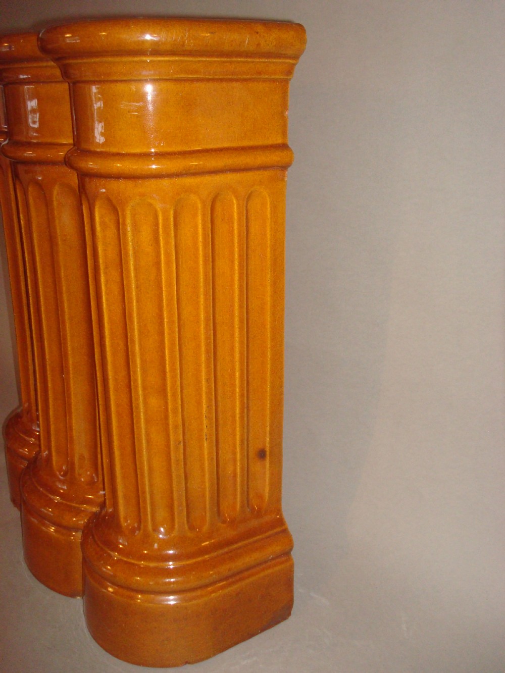 A 19th-century ceramic umbrella stand with an ochre yellow glaze, formed as three connected fluted architectural columns. View VII