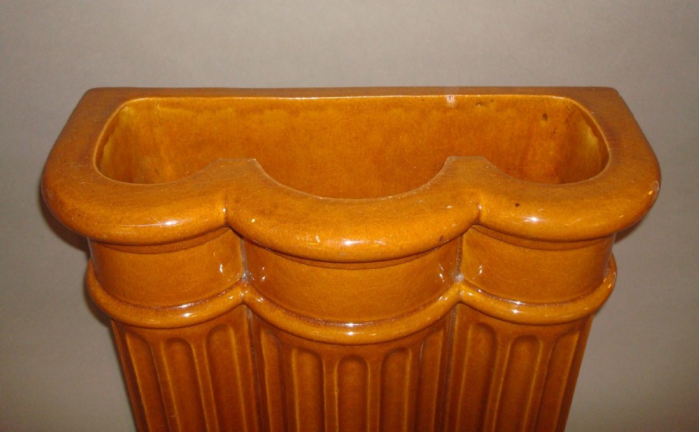 A 19th-century ceramic umbrella stand with an ochre yellow glaze, formed as three connected fluted architectural columns. View IX
