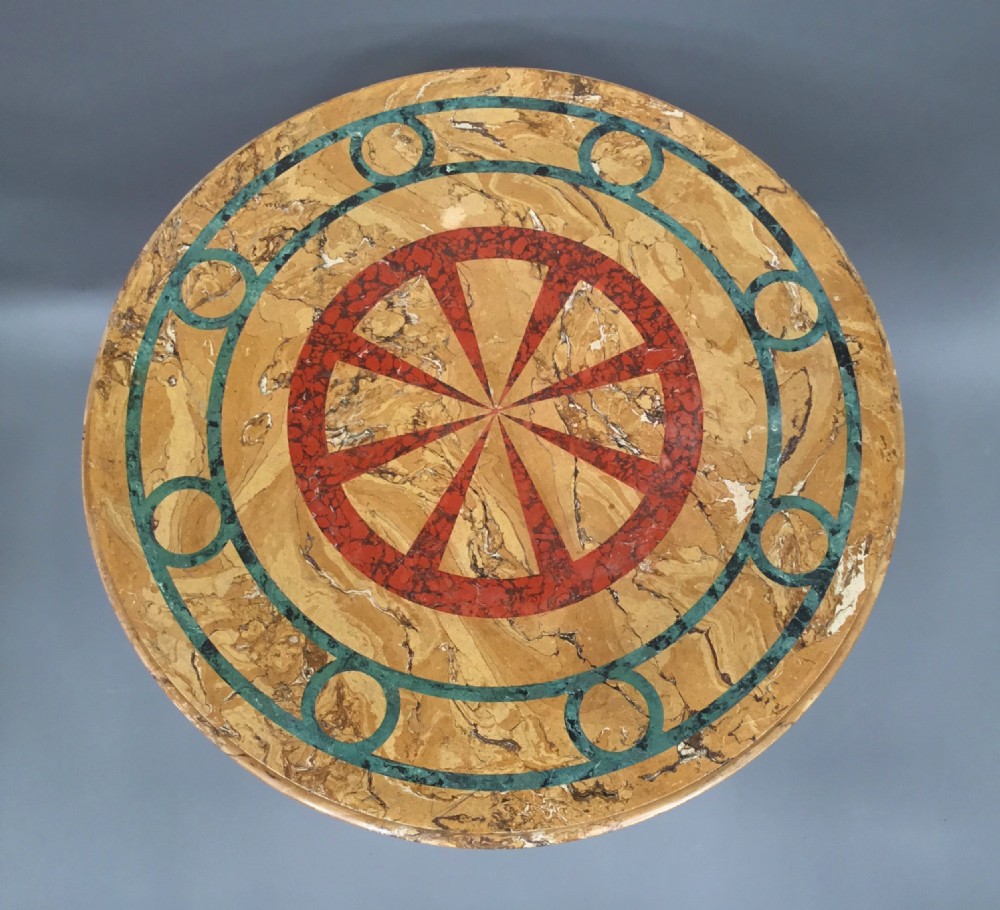 A circular 19th-century Italian scagliola centre table featuring a red wheel motif in the centre, green circular inlay, a cylindrical pedestal, and a tripartite base. View III