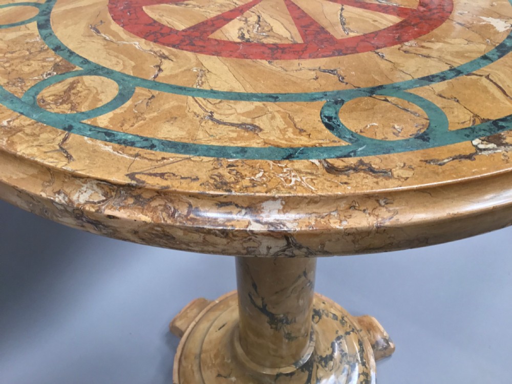 A circular 19th-century Italian scagliola centre table featuring a red wheel motif in the centre, green circular inlay, a cylindrical pedestal, and a tripartite base. View VII