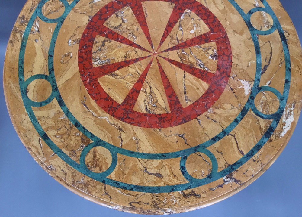 A circular 19th-century Italian scagliola centre table featuring a red wheel motif in the centre, green circular inlay, a cylindrical pedestal, and a tripartite base. View IX