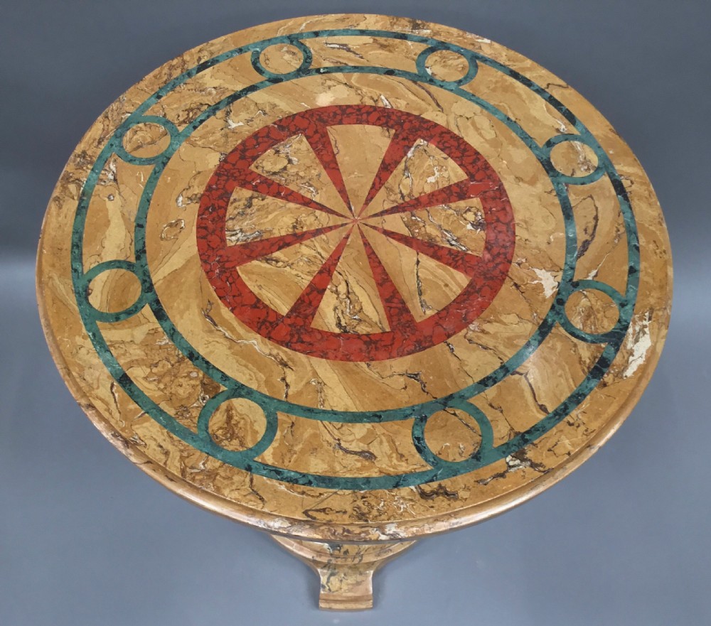 A circular 19th-century Italian scagliola centre table featuring a red wheel motif in the centre, green circular inlay, a cylindrical pedestal, and a tripartite base. View X