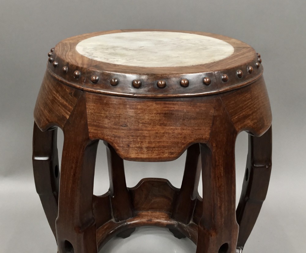 A 19th-century Chinese Hongmu hardwood barrel-form stool featuring a round white marble inset top and carved openwork sides adorned with raised studs. View VII
