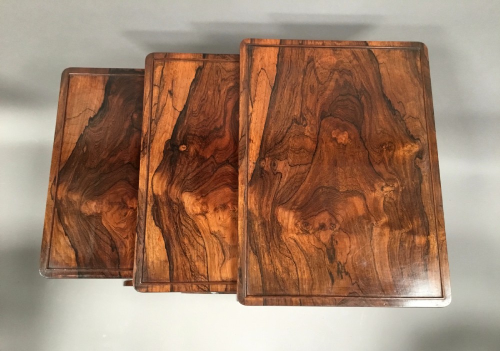 A set of three graduated Regency rosewood nesting tables featuring turned twin-spindle legs and trestle feet. View II