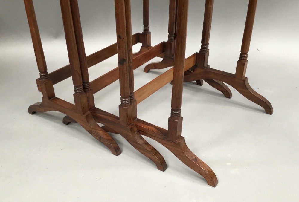 A set of three graduated Regency rosewood nesting tables featuring turned twin-spindle legs and trestle feet. View XII