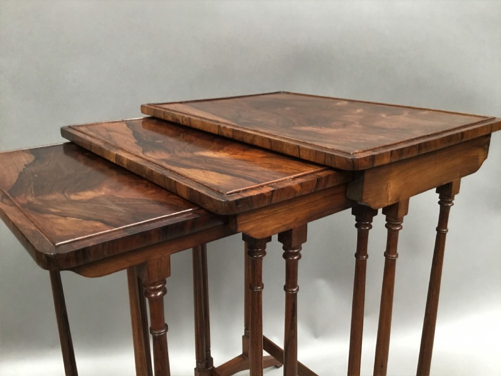 A set of three graduated Regency rosewood nesting tables featuring turned twin-spindle legs and trestle feet. View XIV