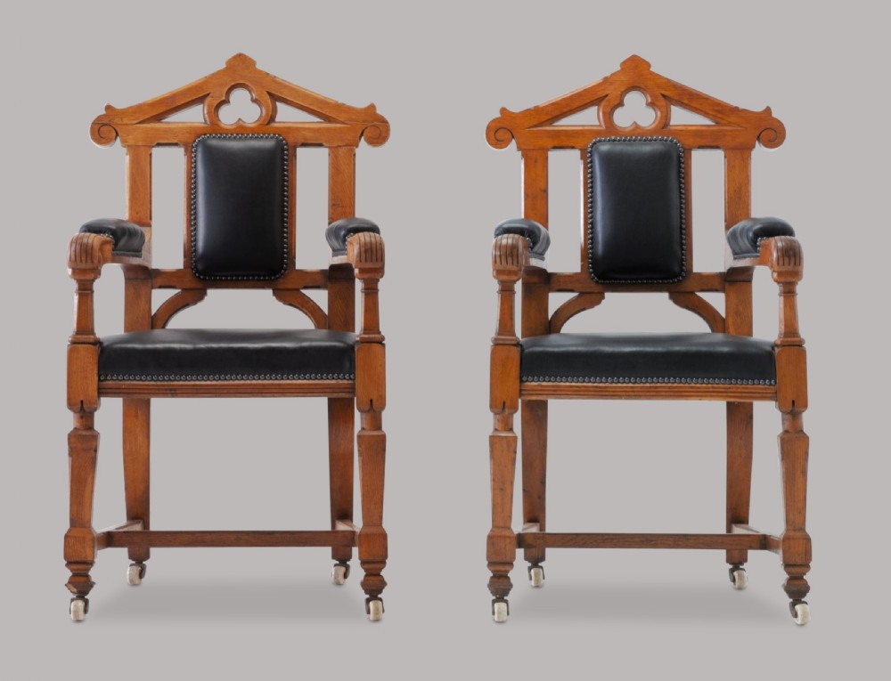 A pair of 19th-century Gothic Revival golden oak open armchairs with black leather upholstery and carved trefoil pediments. View II