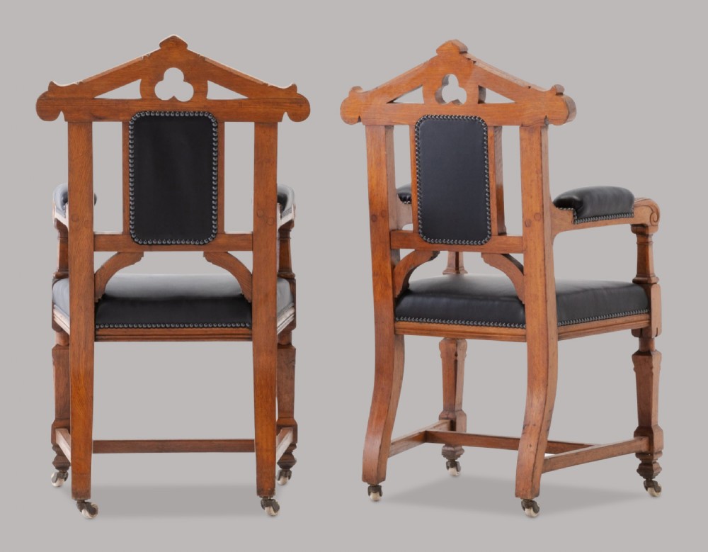 A pair of 19th-century Gothic Revival golden oak open armchairs with black leather upholstery and carved trefoil pediments. View VIII