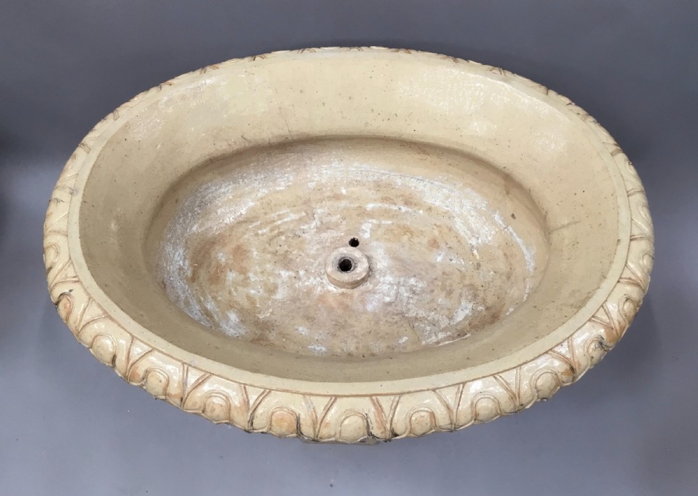 A cream glazed terracotta pedestal urn with a gadrooned lower bowl and an octagonal base featuring incised markings. View XVIII