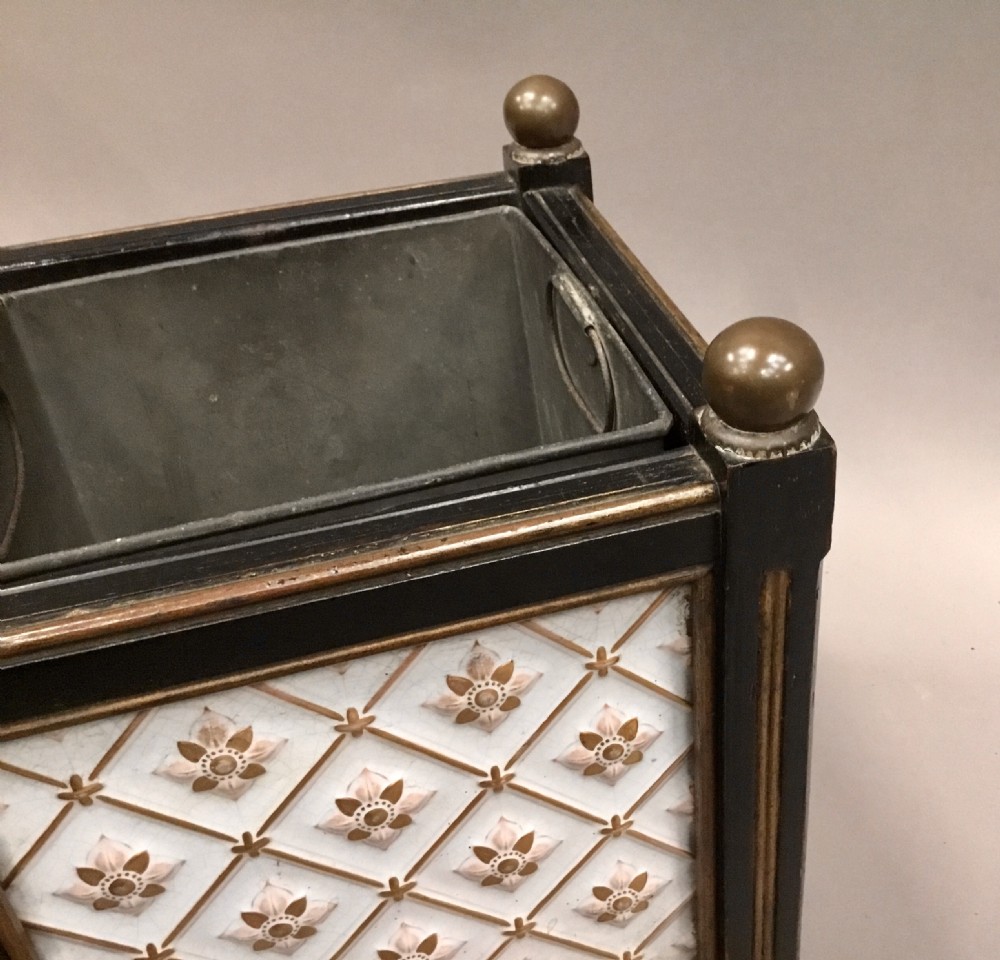 A pair of 19th-century square ebonised wood jardinieres featuring cream ceramic Minton tiles with raised star motifs, brass ball finials, and internal metal liners. View XVIII