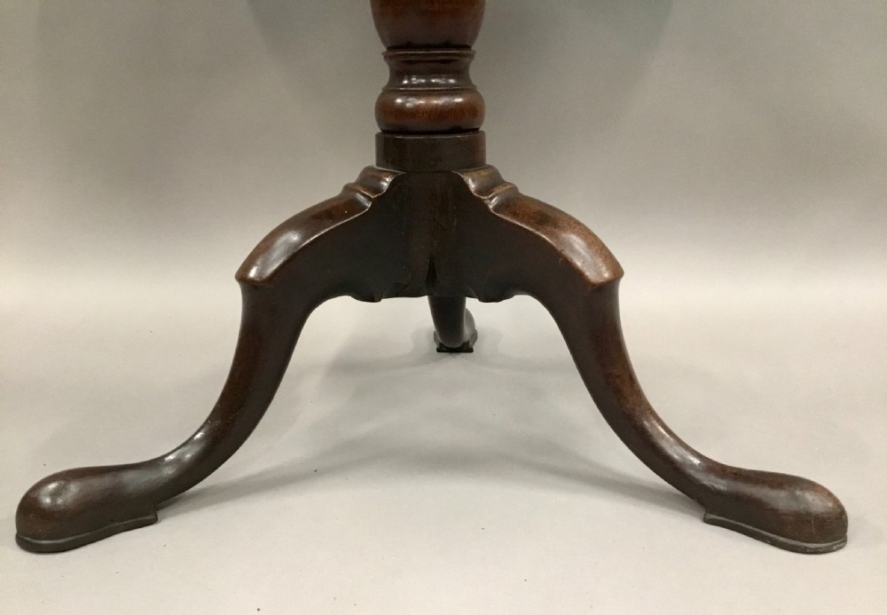 A Georgian dark mahogany tilt-top table featuring a circular top tilted vertically on a turned stem with three cabriole legs. View III