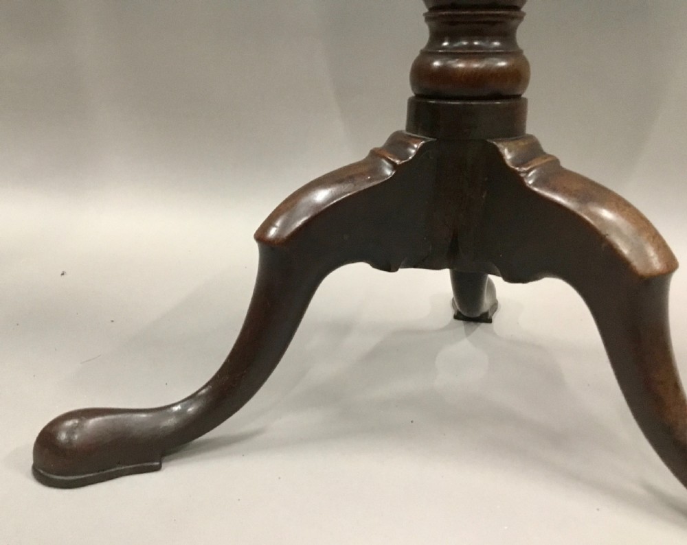A Georgian dark mahogany tilt-top table featuring a circular top tilted vertically on a turned stem with three cabriole legs. View IX