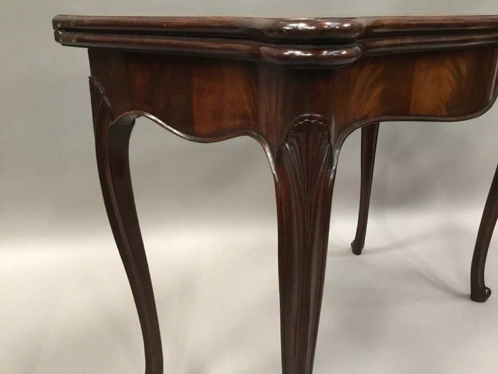A George III mahogany Hepplewhite card table featuring a serpentine apron, shaped cabriole legs, and a hinged fold-over top. View V