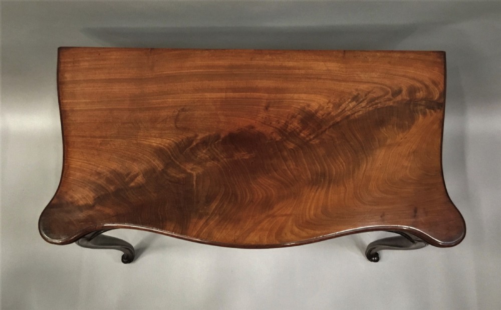 A George III mahogany Hepplewhite card table featuring a serpentine apron, shaped cabriole legs, and a hinged fold-over top. View VIII