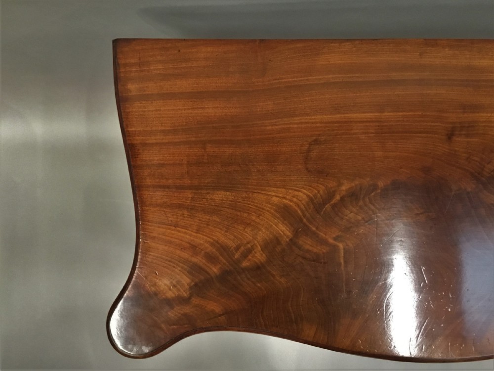 A George III mahogany Hepplewhite card table featuring a serpentine apron, shaped cabriole legs, and a hinged fold-over top. View X