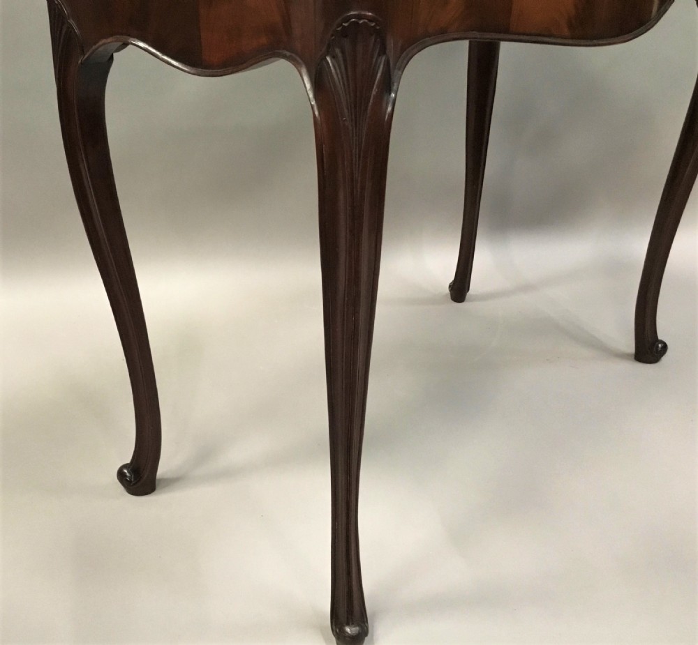 A George III mahogany Hepplewhite card table featuring a serpentine apron, shaped cabriole legs, and a hinged fold-over top. View XII
