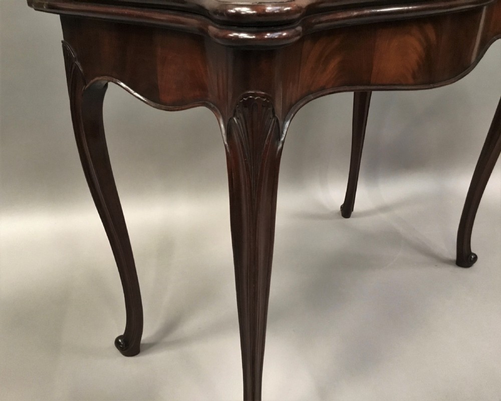 A George III mahogany Hepplewhite card table featuring a serpentine apron, shaped cabriole legs, and a hinged fold-over top. View XV