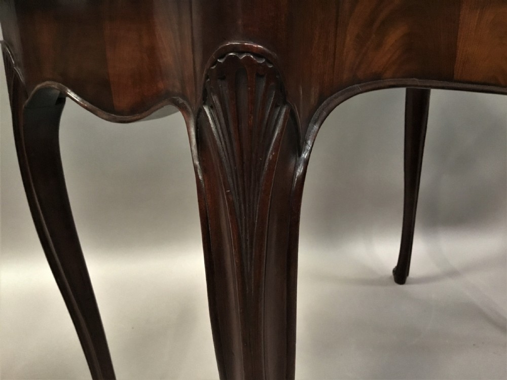 A George III mahogany Hepplewhite card table featuring a serpentine apron, shaped cabriole legs, and a hinged fold-over top. View XVI
