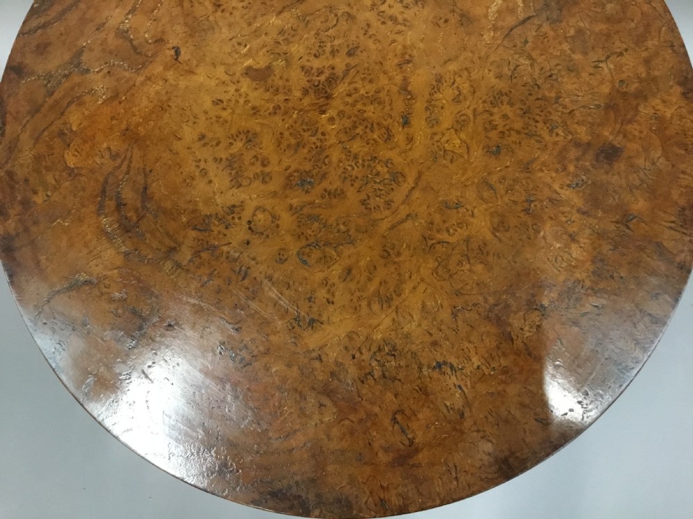 A Regency burr elm occasional table featuring a circular top with detailed grain, supported by an octagonal column and a triform base on bun feet. View IX