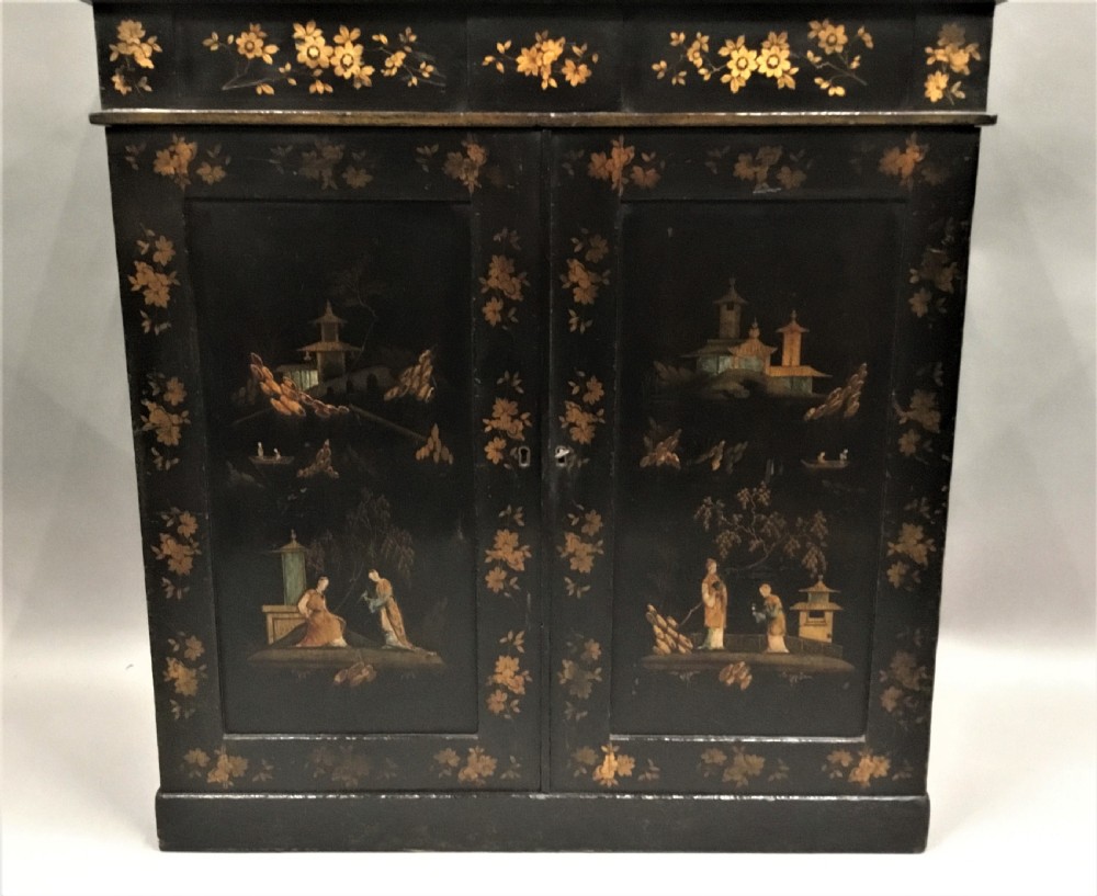 A black lacquered Regency chiffonier side cabinet featuring gold gilded Chinoiserie landscapes, floral borders, a top gallery shelf, and two cupboard doors. View X