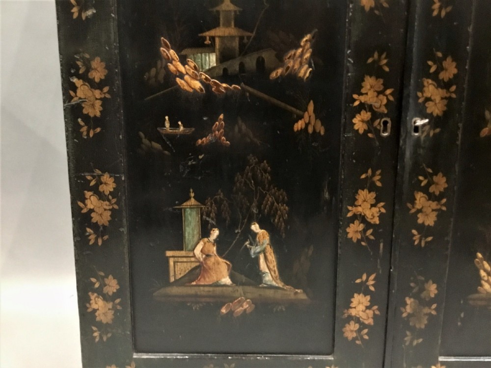 A black lacquered Regency chiffonier side cabinet featuring gold gilded Chinoiserie landscapes, floral borders, a top gallery shelf, and two cupboard doors. View XII