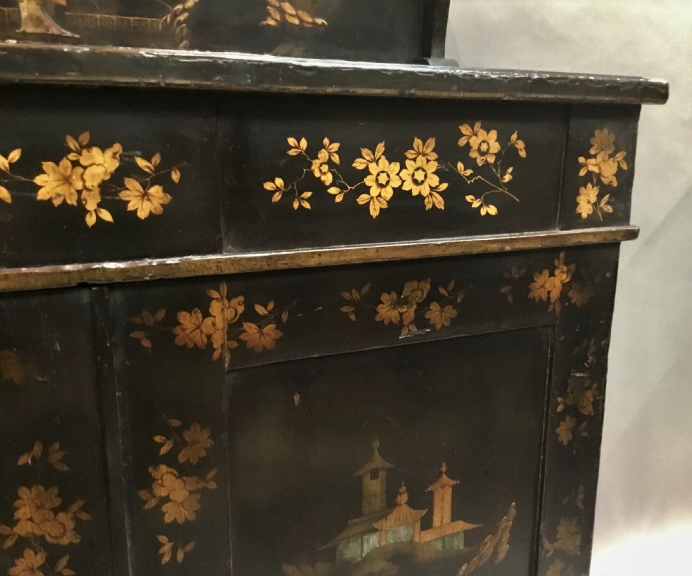 A black lacquered Regency chiffonier side cabinet featuring gold gilded Chinoiserie landscapes, floral borders, a top gallery shelf, and two cupboard doors. View XVI