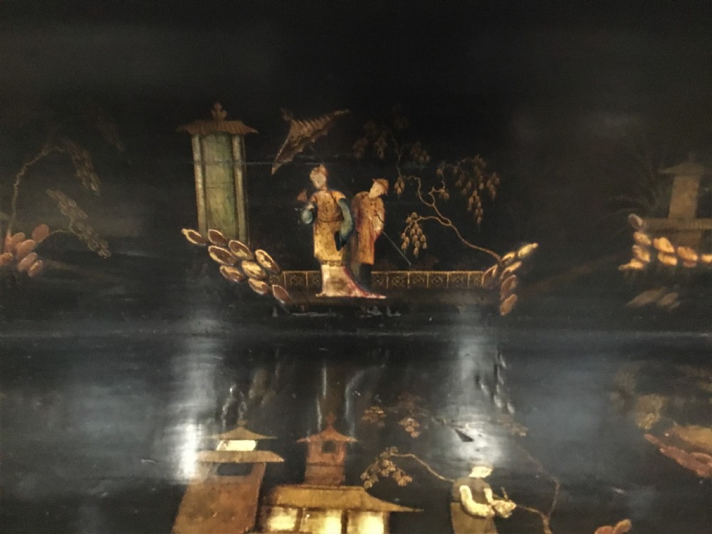A black lacquered Regency chiffonier side cabinet featuring gold gilded Chinoiserie landscapes, floral borders, a top gallery shelf, and two cupboard doors. View XVIII