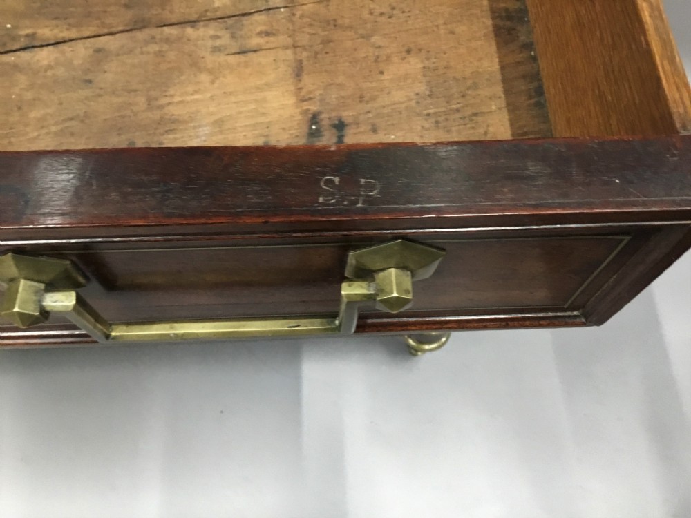 A late 18th-century French Louis XVI neoclassical commode in figured mahogany with a top brass gallery, four drawers, fluted corner stiles, angular brass handles, and turned tapered legs. View VIII