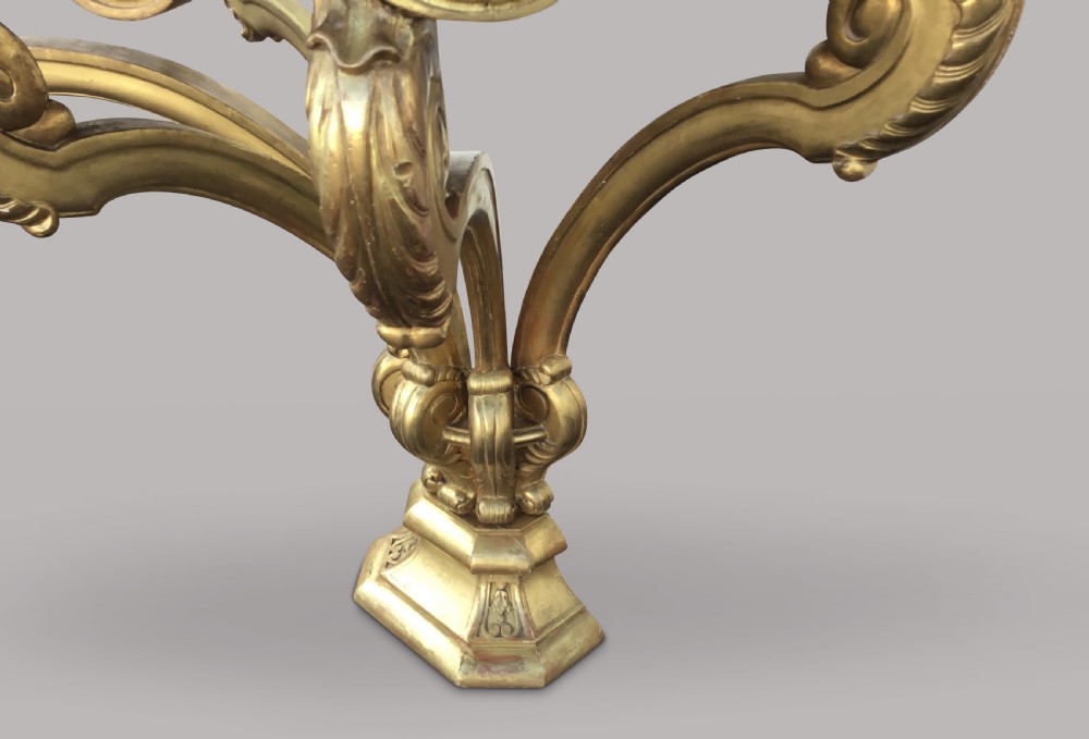 A 19th-century giltwood console table in the Kentian manner featuring a variegated white and grey marble top, carved apron, and central pedestal support with scrolled legs. View XVII