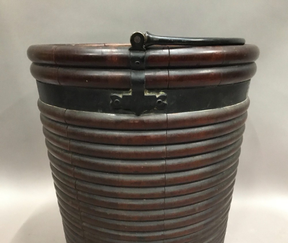 An eighteenth-century mahogany Irish peat bucket featuring a ribbed coopered body, brass banding, and an overhead carrying handle. View VII