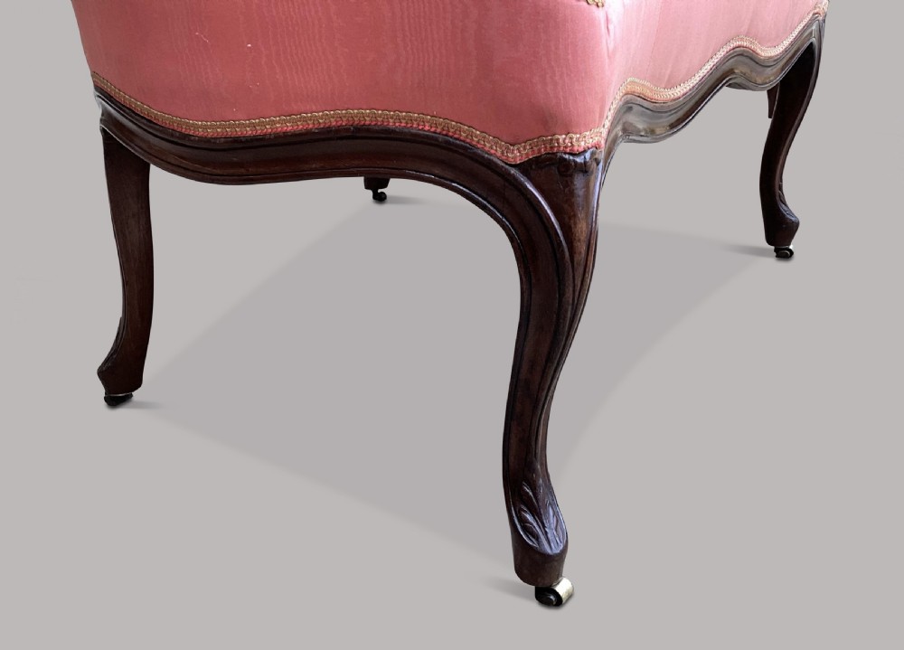 A George III Hepplewhite mahogany settee featuring pink damask upholstery, serpentine backline, and carved cabriole legs on brass castors. View VIII