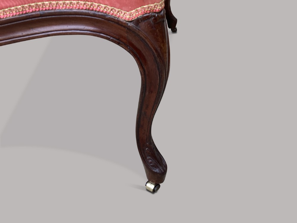 A George III Hepplewhite mahogany settee featuring pink damask upholstery, serpentine backline, and carved cabriole legs on brass castors. View IX
