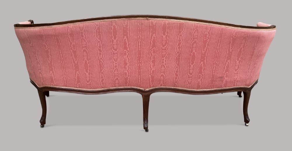 A George III Hepplewhite mahogany settee featuring pink damask upholstery, serpentine backline, and carved cabriole legs on brass castors. View XI