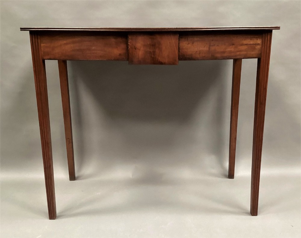 A George III mahogany bow-fronted side table featuring a curved top, frieze panel, and four square tapered legs. View XIII