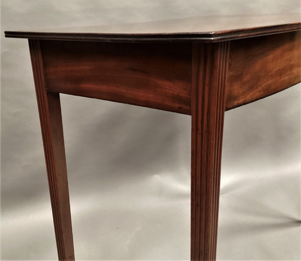 A George III mahogany bow-fronted side table featuring a curved top, frieze panel, and four square tapered legs. View XV